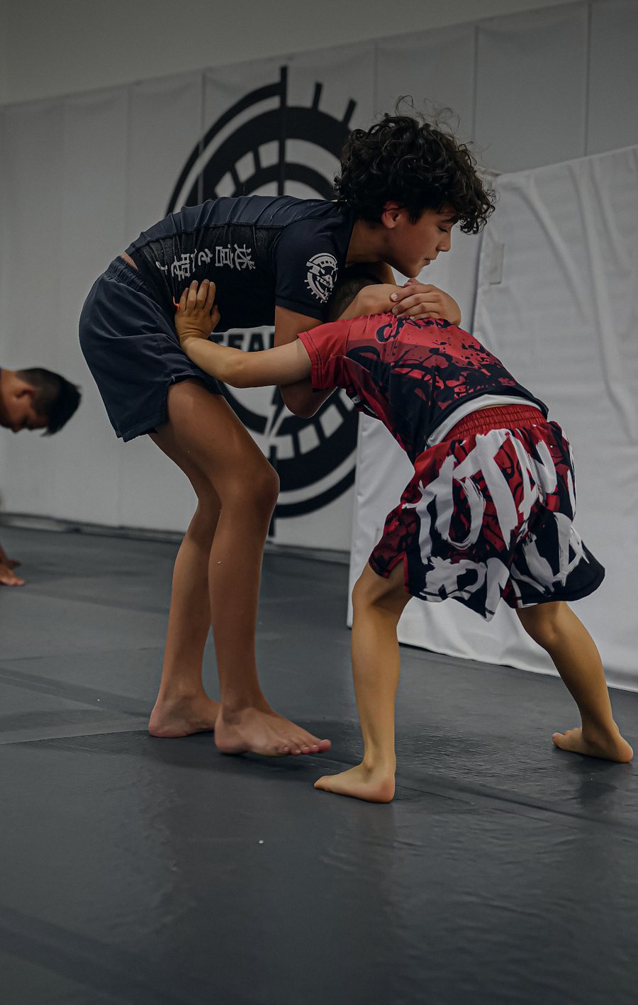 Two young athletes lock up in a wrestling clinch at Labyrinth BJJ in Fulshear, TX